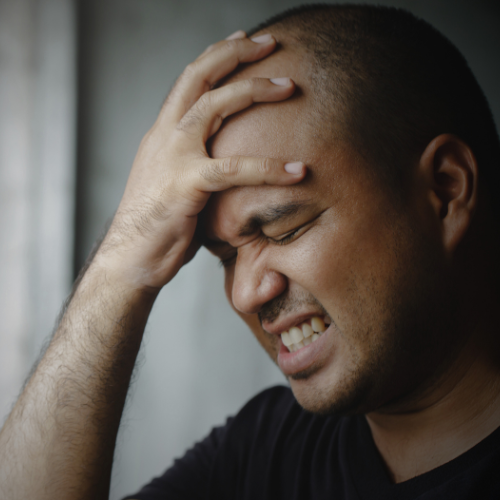 a man grabbing his head due to a headache 