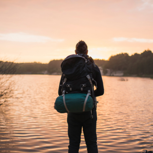 a person standing next to a lake taking a break for mindfulness in survival remedies.